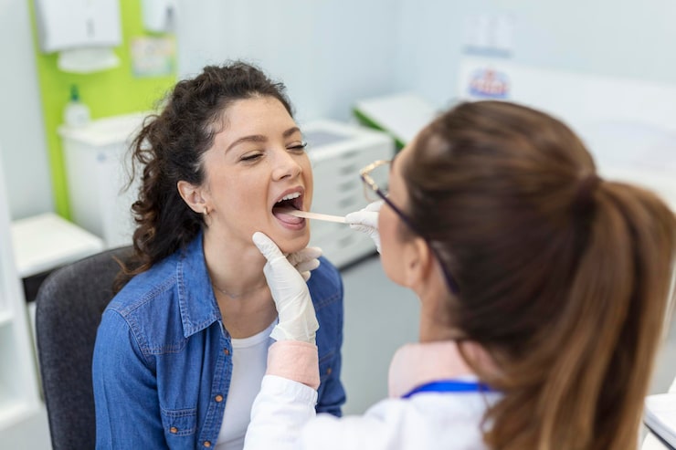 Dentist examining a patient for temporomandibular joint disorder